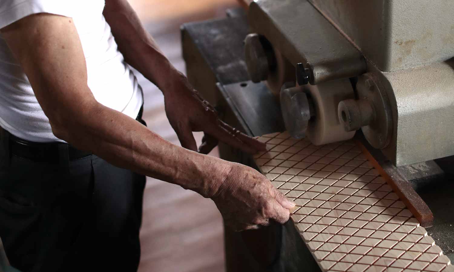 職人が機械を使って木材に切り込みを入れている様子